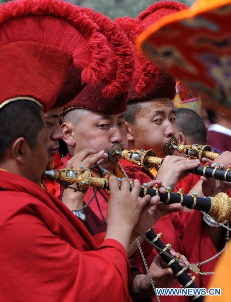 Lamas bugle at the Buddha Tangka painting unfolding ceremony in Curpu Temple, 70 kilometers away from Lhasa, capital of southwest China&apos;s Tibet Autonomous Region, June 12, 2011. The annual Buddha Tangka painting unfolding ceremony was held in Curpu Temple on Sunday. [Xinhua]