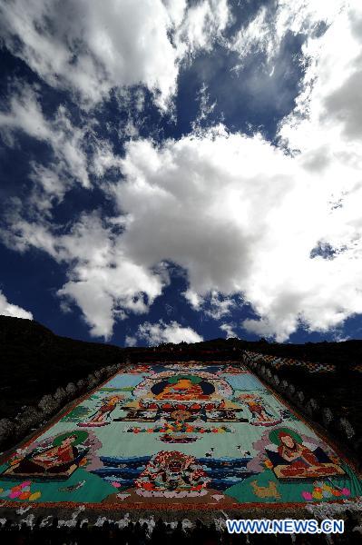 Photo taken on June 12, 2011 shows the Buddha Tangka painting unfolding ceremony in Curpu Temple, 70 kilometers away from Lhasa, capital of southwest China&apos;s Tibet Autonomous Region. The annual Buddha Tangka painting unfolding ceremony was held in Curpu Temple on Sunday. [Xinhua]