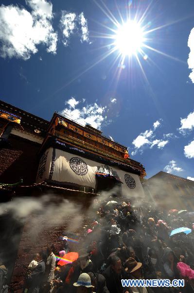 Worshippers attend the Buddha Tangka painting unfolding ceremony in Curpu Temple, 70 kilometers away from Lhasa, capital of southwest China&apos;s Tibet Autonomous Region, June 12, 2011. The annual Buddha Tangka painting unfolding ceremony was held in Curpu Temple on Sunday. [Xinhua]