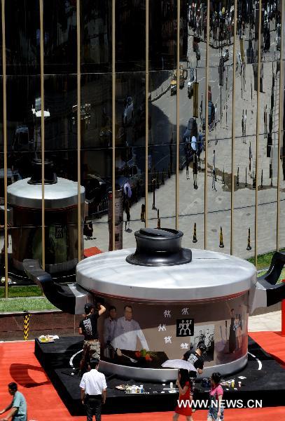 A giant pot model with 4-meter diameter is seen in front a mall in Shenyang, capital of northeast China&apos;s Liaoning Province, June 13, 2011. [Xinhua] 