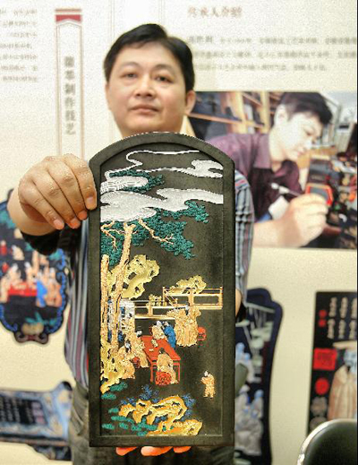 Xiang Shengli, successor of Huizhou Ink, shows his work in an exhibition of Chinese classics and intangible culture heritages in the National Library of China in Beijing, capital of China, June 8, 2011. The exhibition showcases about 200 historical documents about China's intangible heritages and many heritage successors are invited to show their skills on the spot. [Xinhua/Zhao Bing] 