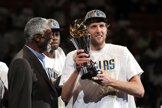 Dirk Nowitzkiof the Dallas Mavericks holds up the Bill Russell Finals MVP trophy after Bill Russell presented it to him following the Mavericks 105-95 win against the Miami Heat in Game Six of the 2011 NBA Finals at American Airlines Arena on June 12, 2011 in Miami, Florida. [Source: Sina.com]