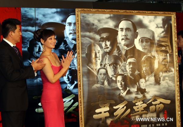Actor Sun Chun (L) and actress Ning Jing unveil a poster of the historical epic 'The Revolution of 1911' during a press conference in east China's Shanghai, June 12, 2011. Three posters of the star-studded film, produced at a cost of more than 100 million yuan (15.42 million U.S. dollars), were released on Sunday. (Xinhua/Ren Long) (ljh) 