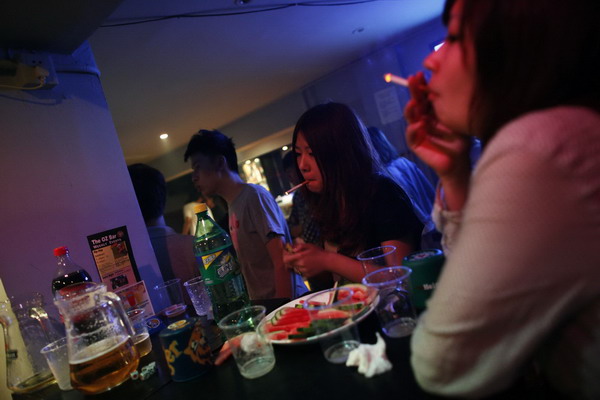 Students smoke during a party after the National College Entrance Exams in Shanghai June 12, 2011. [China Daily/Agencies]