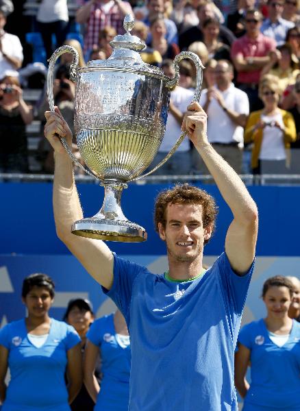 Andy Murray of Britain celebrates with The Queen's Cup after winning the final match against Jo-WilfrIed Tsonga of France in the ATP tournament at Queen's tennis club in London, June 13, 2011. Andy Murray won 2-1 to claim the title. (Xinhua/Tang Shi)