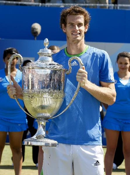 Andy Murray of Britain celebrates with The Queen's Cup after winning the final match against Jo-WilfrIed Tsonga of France in the ATP tournament at Queen's tennis club in London, June 13, 2011. Andy Murray won 2-1 to claim the title. (Xinhua/Tang Shi) 