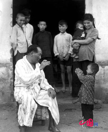 Mao Zedong playing with a kid after swimming in Xiangjiang River, 1959