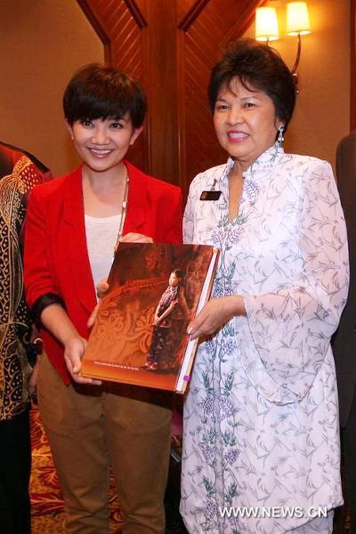 Malaysia's Tourism Minister Ng Yen Yen(R) presents a book to Malaysia's singer Fish Leong in Kuala Lumpu,Malaysia on June 14, 2011.Malaysia's Tourism Ministry announced on Tuesday Fish Leong as ambassador of Malaysia's tourism to promote the industry.[Xinhua] 