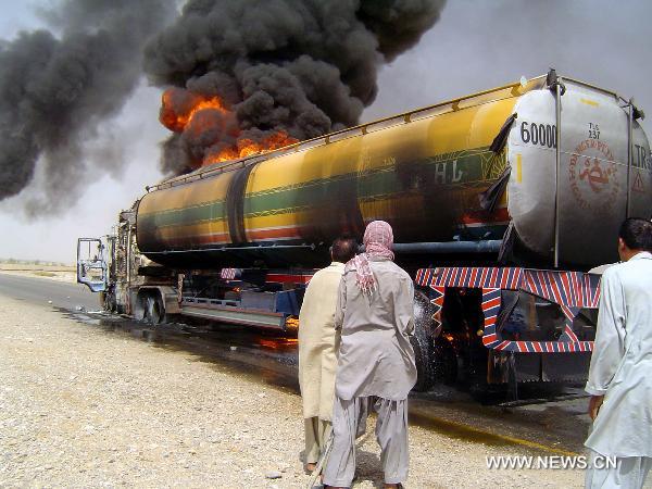 People gather near a burning NATO oil tanker near southwest Pakistan's Sibi on June 15, 2011. At least one driver was injured following an attack on two NATO oil tankers by unknown gunmen. [Iqbal Hussain/Xinhua]