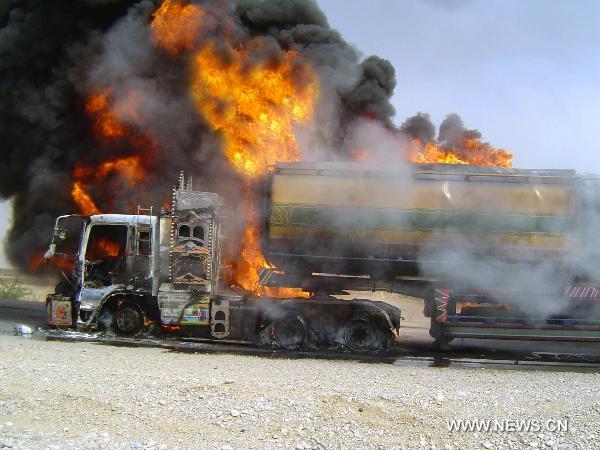 Fire rages from a NATO oil tanker near southwest Pakistan's Sibi on June 15, 2011. At least one driver was injured following an attack on two NATO oil tankers by unknown gunmen. [Iqbal Hussain/Xinhua]