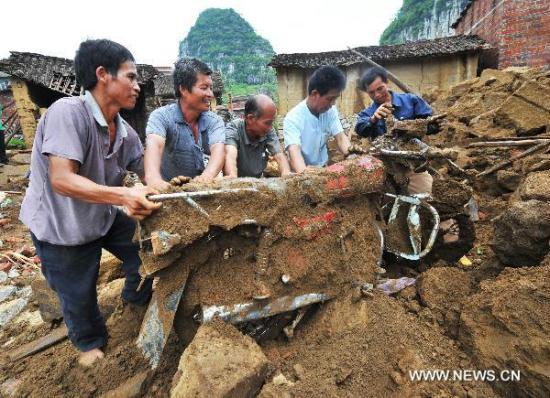 Villagers of Xincheng County retrieve a motorcycle from the muddy rubbles left by the flood in Laibin, south China's Guangxi Zhuang Autonomous Region, June 17, 2011. Local authorities in Laibin have organized a series of relief actions after a heavy flood struck the city earlier this month, ruining over 600 houses. [Xinhua]