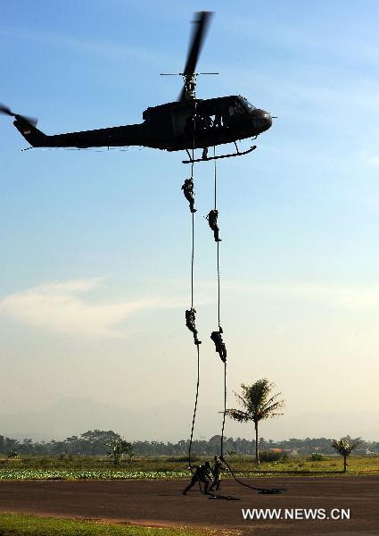 Soldiers of special forces from China's People's Liberation Army (PLA) and Indonesia's National Armed Forces (TNI) slide down the rope from a helicopter during a united training in Bandung, Indonesia, June 17, 2011. The united training, with a code name of 'Sharp Knife 2011', closed on Friday. It was the first one between PLA and TNI in the history. [Jiang Fan/Xinhua]