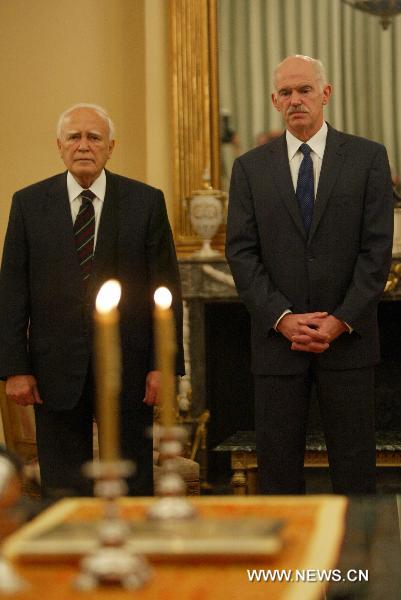 Greek President Karolos Papoulias (L) and Prime Minister George Papandreou attend the new government inauguaration ceremony in Athens, Greece, June 17, 2011. Greece's new government lead by Prime Minister George Papandreou was sworn in Friday, shortly after a broad reshuffle made 20 months since the socialist ruling party took office amidst an acute debt crisis. [Marios Lolos/Xinhua]