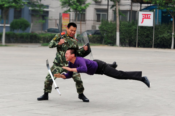 A member of the Chinese armed police subdues a 'terrorist' during an anti-terrorism demonstration in Beijing to celebrate the 90th anniversary of Communist Party of China, June 16, 2011. [Photo/CFP]