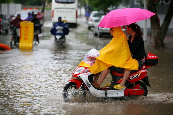 Motorbikes wade through a flooded road in Nanjing, capital of East China Jiangsu province, June 18, 2011. [Photo/Xinhua] 