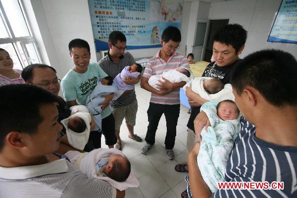 Freshmen fathers hold their babies in the No. 1 People's Hospital in Xiangyang, central China's Hubei Province, June 18, 2011. [Xinhua/Gong Bo]