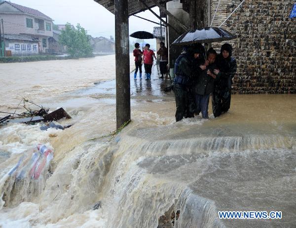 Armed policemen help evacuate villagers in Longtoushan Town of Dexing City, east China's Jiangxi Province, June 19, 2011. 