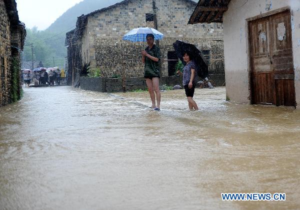 Villagers stand in flood in Longtoushan Town of Dexing City, east China's Jiangxi Province, June 19, 2011. 