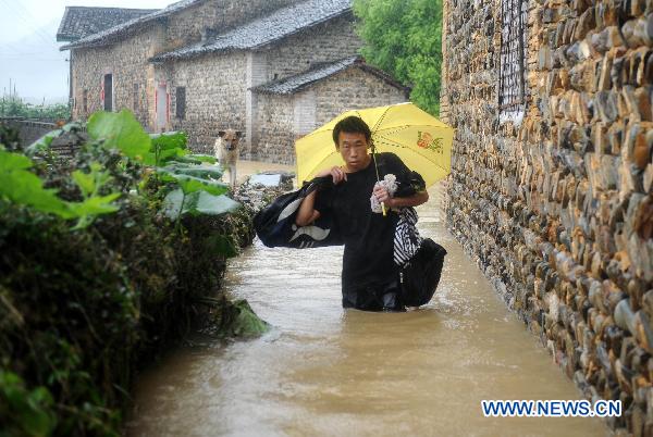 A villager makes his way forward in flood in Longtoushan Town of Dexing City, east China's Jiangxi Province, June 19, 2011. 