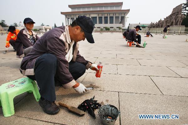 Workers clean the tiles in Tian'anmen Square in Beijing, capital of China, June 19, 2011.