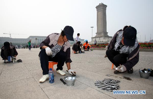 Workers clean the tiles in Tian'anmen Square in Beijing, capital of China, June 19, 2011. 