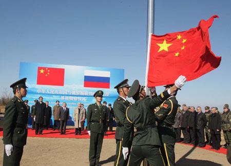 Chinese soldiers raise a national flag during a ceremony on the Heixiazi Island Oct. 14, 2008.
