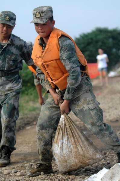 PLA soldiers use sandbags for reinforcement of a dike in Lanxi city, East China's Zhejiang province, June 20, 2011