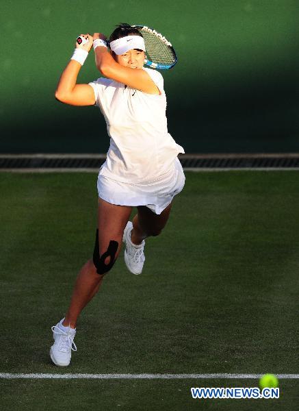 Li Na of China returns the ball during her first round match against Alla Kudryavtseva of Russia at the 2011 Wimbledon tennis championships in London, Britain, June 21, 2011. Li won 2-0. (Xinhua/Zeng Yi) 