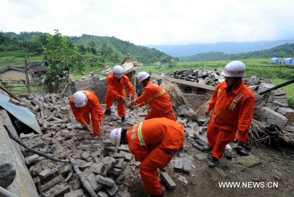 Rescuers clear the ruins caused by an earthquake in Tengchong County, southwest China's Yunnan Province, June 21, 2011. The 5.2-magnitude earthquake that hit Tengchong on Monday has left six people injured and caused significant economic losses, the Ministry of Civil Affairs said Tuesday. As of 3 p.m. Tuesday, the quake had affected 22,000 local residents and led to the emergency relocation of 2,168 people. The local government has allocated 7 million yuan to set up a disaster relief fund, as well as sent hundreds of tents, quilts and articles of clothing to the quake zone, according to the ministry. (Xinhua/Yang Zongyou) (hdt) 