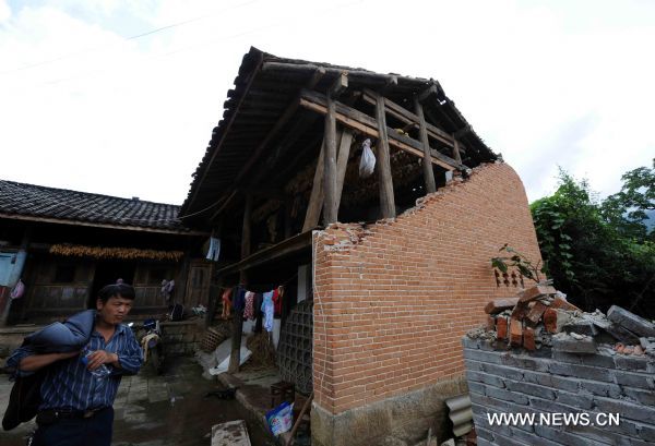 A resident is seen in front of his house damaged by an earthquake in Tengchong County, southwest China's Yunnan Province, June 21, 2011. The 5.2-magnitude earthquake that hit Tengchong on Monday has left six people injured and caused significant economic losses, the Ministry of Civil Affairs said Tuesday. As of 3 p.m. Tuesday, the quake had affected 22,000 local residents and led to the emergency relocation of 2,168 people. The local government has allocated 7 million yuan to set up a disaster relief fund, as well as sent hundreds of tents, quilts and articles of clothing to the quake zone, according to the ministry. (Xinhua/Yang Zongyou) (hdt) 