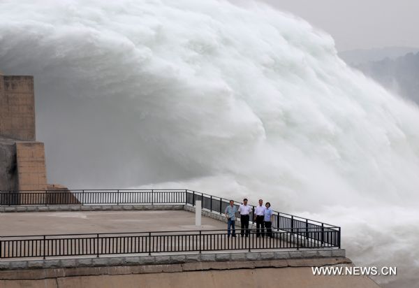 Tourists appreciate the torrents gushing out from the Xiaolangdi Reservoir on the Yellow River, at the reservoir's viewing platform, in Jiyuan, central China's Henan Province, June 21, 2011. The Yellow River Flood Control and Drought Relief Headquarters launched on Sunday a 20-day operation to discharge water from three reservoirs, namely Wanjiazhai, Sanmenxia and Xiaolangdi, in a bid to clear up the sediment in the river. (Xinhua/Miao Qiunao) (hdt) 