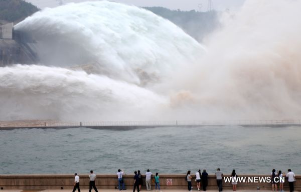 Tourists appreciate the torrents gushing out from the Xiaolangdi Reservoir on the Yellow River, at the reservoir's viewing platform, in Jiyuan, central China's Henan Province, June 21, 2011. The Yellow River Flood Control and Drought Relief Headquarters launched on Sunday a 20-day operation to discharge water from three reservoirs, namely Wanjiazhai, Sanmenxia and Xiaolangdi, in a bid to clear up the sediment in the river. (Xinhua/Miao Qiunao) (hdt) 