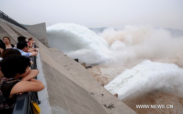 Tourists appreciate the torrents gushing out from the Xiaolangdi Reservoir on the Yellow River, at the reservoir's viewing platform, in Jiyuan, central China's Henan Province, June 21, 2011. The Yellow River Flood Control and Drought Relief Headquarters launched on Sunday a 20-day operation to discharge water from three reservoirs, namely Wanjiazhai, Sanmenxia and Xiaolangdi, in a bid to clear up the sediment in the river. (Xinhua/Miao Qiunao) (hdt) 