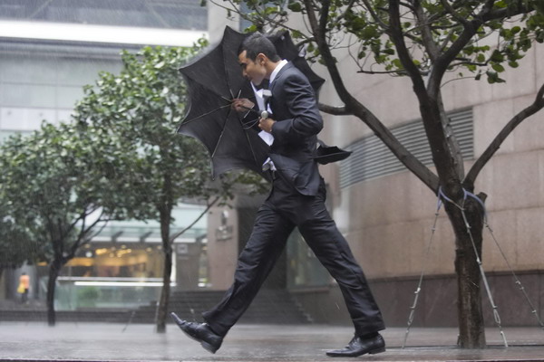 A Hong Kong resident walks in a rain storm as Haima approaches on June 22, 2011. [Xinhua] 