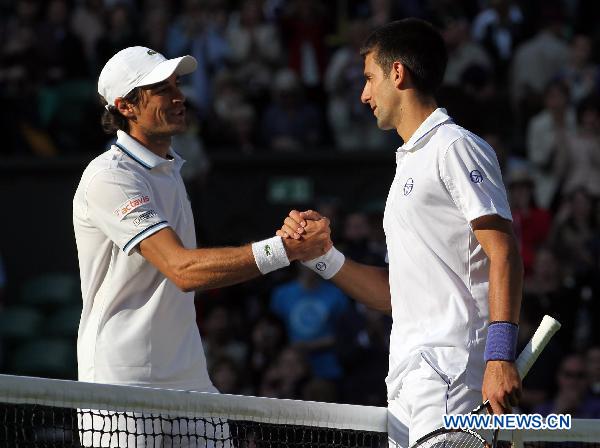 Novak Djokovic (R) of Serbia greets Jeremy Chardy of France after their first round match at the 2011 Wimbledon tennis championships in London, Britain, June 21, 2011. Novak Djokovic won 3-0. (Xinhua/Tang Shi) 