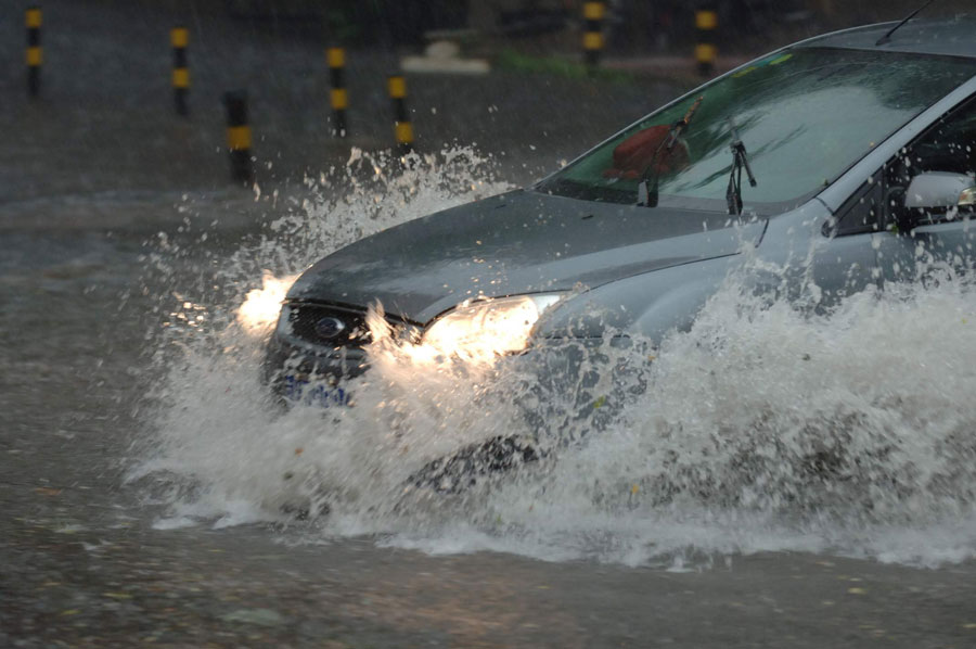 A car moves in water on a street in Beijing, capital of China, June 23, 2011. Rainstorms pounded the Chinese capital Thursday afternoon. The storms delayed flights, slowed road traffic and disrupted the operation of two subway lines in the afternoon rush hours. [Xinhua]