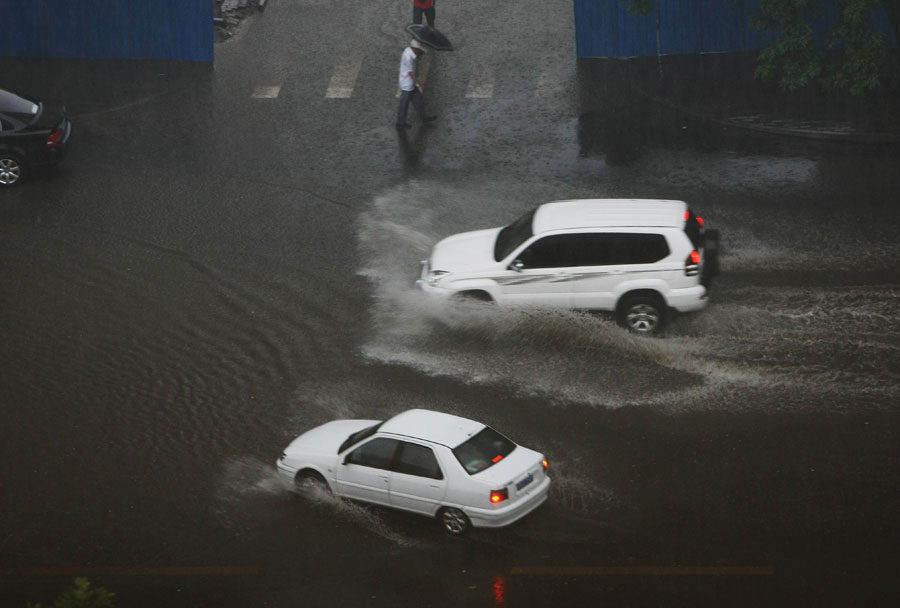 Cars move in water on a street in Beijing, capital of China, June 23, 2011. Rainstorms pounded the Chinese capital Thursday afternoon. The storms delayed over 140 flights, slowed road traffic and disrupted the operation of two subway lines in the afternoon rush hours. [Xinhua]