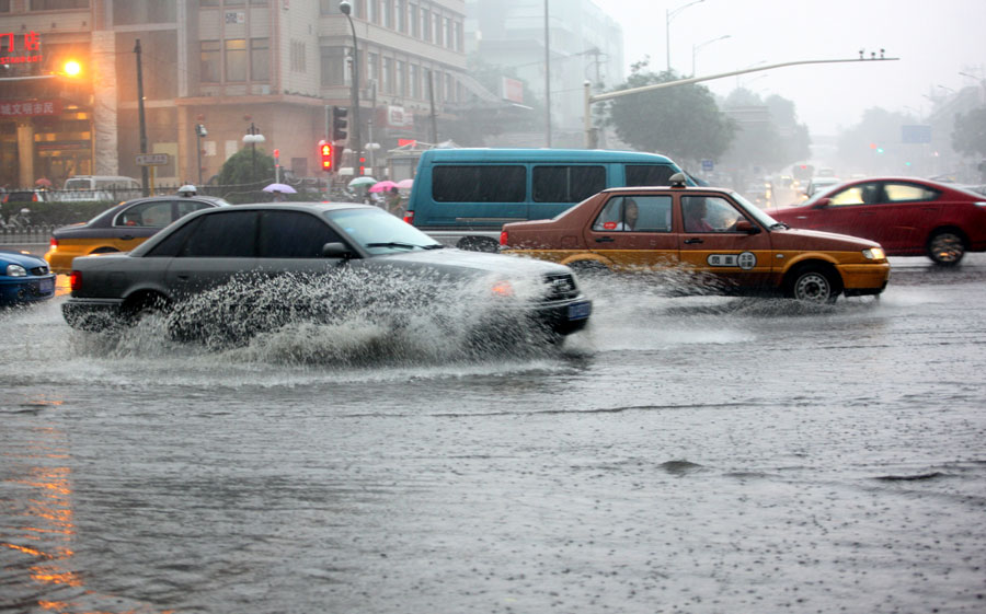 Cars move in water on a street in Beijing, capital of China, June 23, 2011. Rainstorms pounded the Chinese capital Thursday afternoon. The storms delayed over 140 flights, slowed road traffic and disrupted the operation of two subway lines in the afternoon rush hours. [Xinhua]