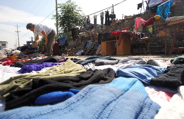 Villagers dry clothes in Sanjiangkou Village of Zhuji City, east China's Zhejiang Province, June 22, 2011. Local people resumed farm work to recover from damages caused by floods on the sunny day.