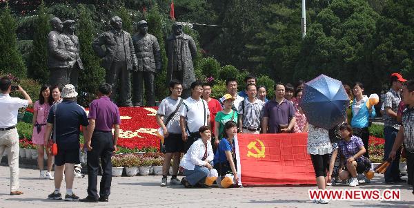 Visitors pose for group photo at Xibaipo Memorial Museum at Xibaipo, a village in north China's Hebei Province, June 19, 2011. Xibaipo and other revolutionery bases become hot tourist destinations this year, as red tourism blossomed with the arrival of the 90th anniversary of the founding of the Communist Party of China. The village has received over 2.1 million tourists this year. [Xinhua/Ding Lixin]