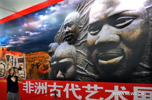 A visitor takes photos at an exhibition highlighting the ancient African culture in Luoyang museum in Luoyang, central China's Henan Province, June 22, 2011. More than 160 craftworks of ancient African culture, including the wood carving, the stone carving, masks and so on, were displayed at the exhibition. Some of the exhibits have the history of thousands years.