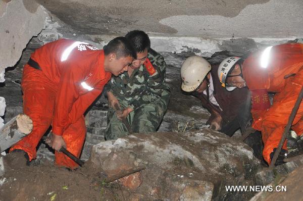 Rescuers search trapped persons at the site of a landslide in Baihe Village of Jingnan Township in Xingyi, southwest China's Guizhou Province, June 23, 2011. 