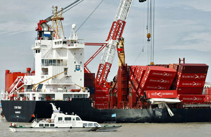 Rescue workers unload containers from the CCNI Rimac near the Yangshan Deep-Water Port in Shanghai yesterday.