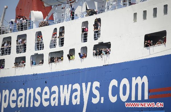 Passengers wave as International Red Cross ship the Ionis arrives to the rebel port of Benghazi, Libya, June 24, 2011. [Xinhua/Dai Xuming]