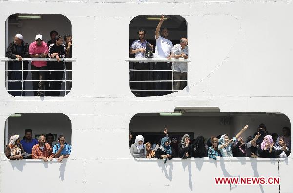 Passengers wave as International Red Cross ship the Ionis arrives to the rebel port of Benghazi, Libya, June 24, 2011. [Xinhua/Dai Xuming] 