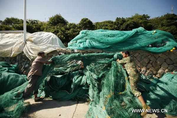 Fishermen put away fishing nets before the tropical storm Meari arrives in Zhoushan, east China's Zhejiang Province, June 24, 2011. Fishermen in east China's Zhoushan have been taking precaution against Meari, a tropical storm which is about to hit the region Saturday afternoon. Surrounded by the East China Sea, Zhoushan is a major fishery center in China. [Xinhua/Hu Sheyou] 