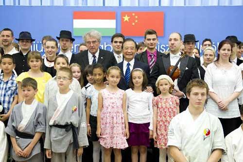 Chinese Premier Wen Jiabao (C) poses for a group photo with students and teachers after attending a cultural exchange activity at the Eotvos Lorand University in Budapest, Hungary, June 24, 2011. [Xinhua/Huang Jingwen]