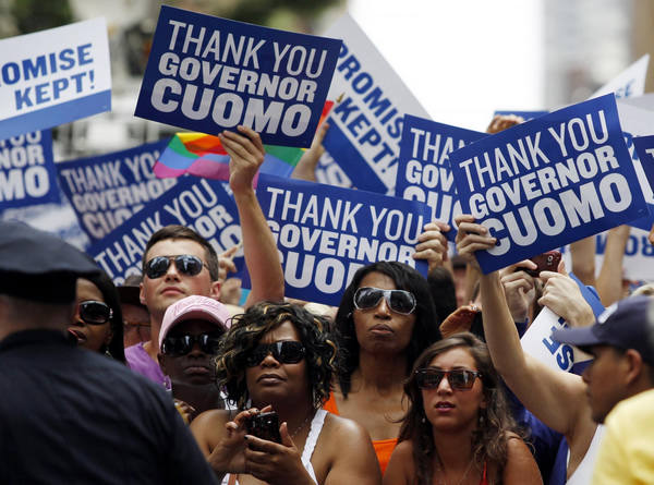 People lining the parade route hold signs thanking New York Governor Andrew Cuomo for the legalization of gay marriage during the Gay Pride Parade in New York June 26, 2011. [Photo/Agencies] 