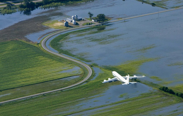 A US Air Force jet flies over flooded Iowa farm grounds east of Offutt Air Force Base in Bellevue, Nebraska June 24, 2011.