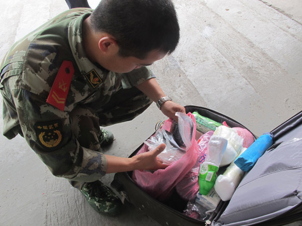 A soldier checks a suitcase for drugs at Mukang frontier inspection station, Yunnan province, on Friday. 